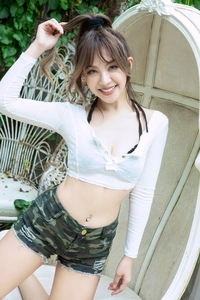 Detail von Camouflage-Jeans-Shorts mit Fransensaum und weißem, geknöpftem bauchfreiem Oberteil