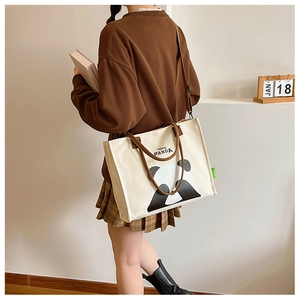 Detail of canvas tote bag showing the panda print and adjustable shoulder straps