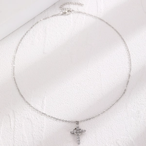 Macro view of silver cross pendant necklace with sparkling rhinestones and metal chain