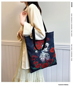 Detail of black canvas tote bag featuring Mexican Sugar Skull girl and red roses print