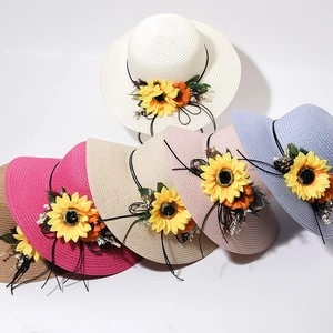 Close-up of colorful straw sun hats featuring large sunflowers and elegant ribbons