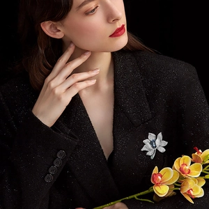 Luxuriöse Blumenbrosche mit blauem Kristall und Diamanten auf schwarzem Blazer