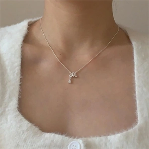 Close-up of a 925 sterling silver bow necklace with zircon teardrop worn by a woman