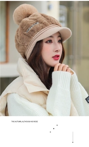 Detail of khaki plush winter hat with faux rabbit fur earflaps and large soft pom-pom