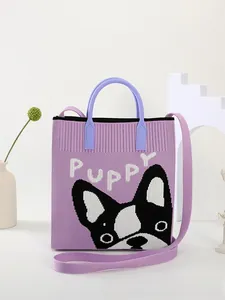 Close-up of purple knitted tote bag featuring a white Puppy logo and French bulldog pattern