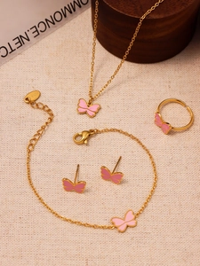 Detailed set of gold butterfly jewelry including necklace and rings on beige fabric