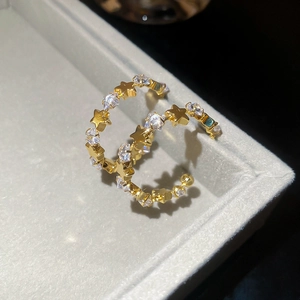 Close-up of gold star hoop earrings with sparkling cubic zirconia on a gray tray