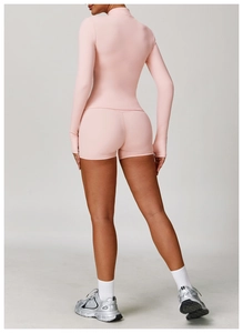 Vista posteriore del set yoga rosa con top a maniche lunghe e pantaloncini a vita alta