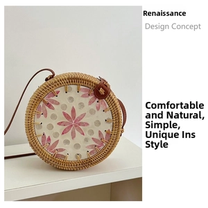 Detail of round rattan crossbody bag featuring pink shell petals and leather buckle strap