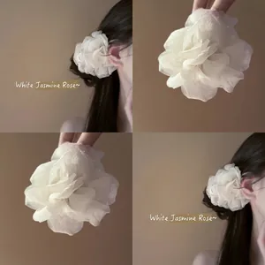 Pinza per capelli con fiore in tessuto bianco e tulle mostrata in diverse angolazioni