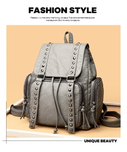 Close-up of grey washed leather backpack with decorative metal stud detailing
