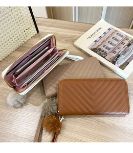 Detail of V-quilted long wallets with fluffy ball charms and multi-slot interior space