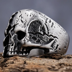 Macro detail of retro aviator skull ring with aged silver texture on wood surface