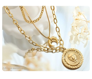 Close-up of triple-layered 18K gold-plated necklace with lion and moon pendants