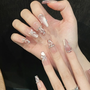 Detail of long ballerina press-on nails with pink cat-eye effect and 3D butterfly charms