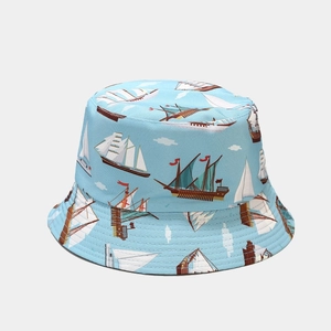 Detailed view of sun bucket hat featuring blue nautical prints with sailboats and clouds