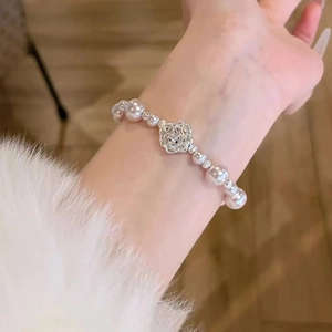 Bracelet élégant en perles et fleurs de zircon pour femme porté sur le poignet