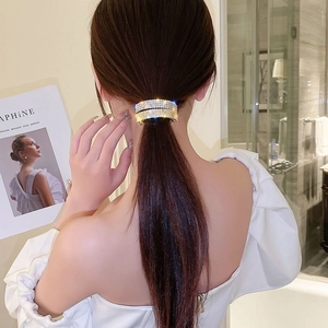 Pince à queue de cheval étincelante avec base dorée et strass pour coiffure élégante