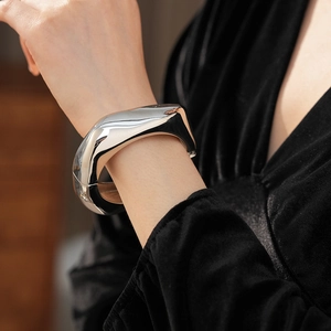 Detail of silver irregular sculptural cuff bracelet featuring a liquid metal finish