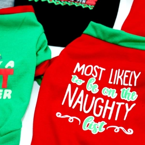 Detail of soft cotton Christmas dog t-shirts with naughty list festive holiday prints