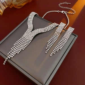 Close-up of silver-tone water drop tassel necklace and earrings with sparkling rhinestones