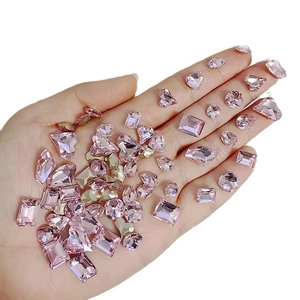 Pink mixed-shape nail crystals held in hand showing various emerald and heart cuts