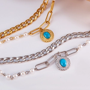 Close-up of double-layer stainless steel bracelet with pearls and turquoise pendant