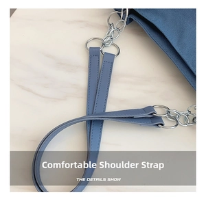 Close-up of the durable blue leather and silver chain strap on a canvas tote bag