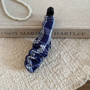 Détail du tissu à carreaux bleu et blanc recouvrant la pince à cheveux banane coréenne
