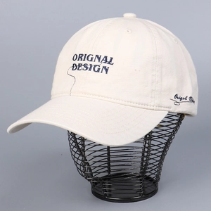 Detailed close-up of beige cotton baseball cap with navy blue letter embroidery