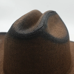 Macro detail of dark brown woven straw cowboy hat with gradient spray paint texture