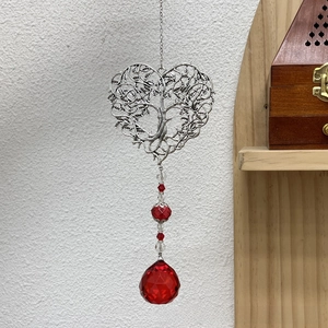Detail of tree of life silver heart pendant with faceted red crystal teardrop prism