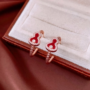 Detail of red enamel gourd earring with diamond edge in luxury jewelry box