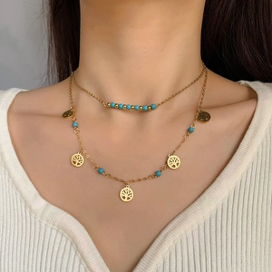 Détail d'un collier double rang avec pendentif arbre de vie et perles bleu émail