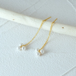 Detail of S925 silver gold chain earrings featuring triple white pearl clusters