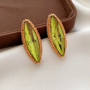 Detail of marquise cut lime green gemstone earrings with rose gold beaded border decor