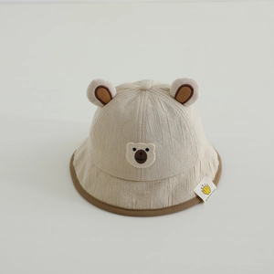 Détail d'un chapeau bob pour bébé beige avec oreilles d'ours et broderie mignonne