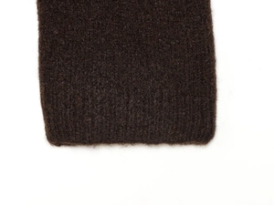 Detailed macro view of dark brown knit fabric with ribbed cuff texture and mohair finish