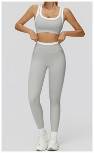 Detail der grauen High-Waist-Yoga-Leggings und passender Sport-BH mit weißem Paspelrand