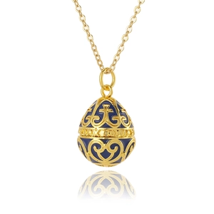 Detailed macro view of a gold and blue enamel egg pendant with intricate cutout patterns