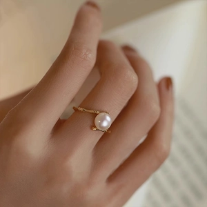Elegant gold bamboo joint ring with white pearl in a minimalist open design for women