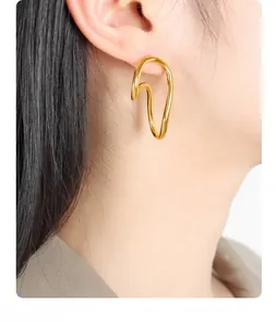 Close-up of a model wearing minimalist 18K gold plated double hoop geometric earrings