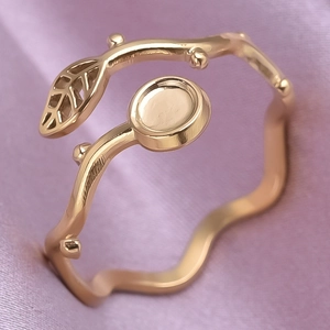 Macro shot of gold leaf branch open ring showing detailed leaf texture and metallic finish
