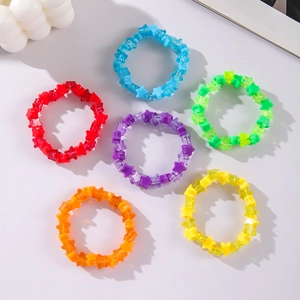 Flat lay of colorful acrylic star-shaped rings in red, blue, green, and purple