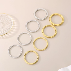 Detailed view of polished hollow tube bangles in gold and silver titanium steel