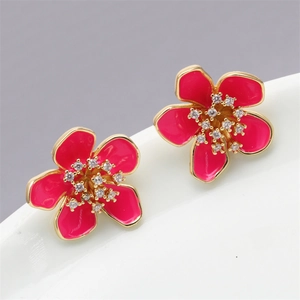 Close-up of rose red flower earrings with micro-inlaid zircons and golden metal edges