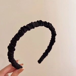 French style pleated black headband for women with premium silk texture on beige background