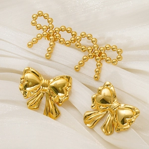 Gold-plated stainless steel bow earrings and jewelry set on white silk background