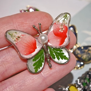 Broche papillon créative avec fleurs séchées rouges et vertes et détail de perle