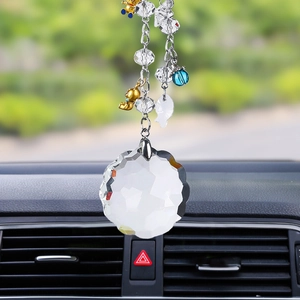 Detailed view of crystal car pendant with faceted heart and cross on silver metal chain